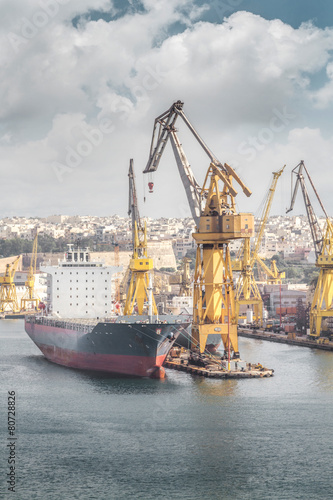 Cargo ship with crane in the harbor, Valletta, Malta