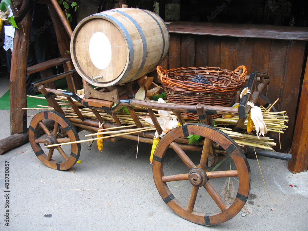 Old wooden cart with wooden barrel and grapes