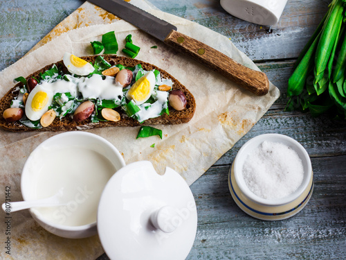 rye bread with wild garlic, sour cream and quail eggs and beans