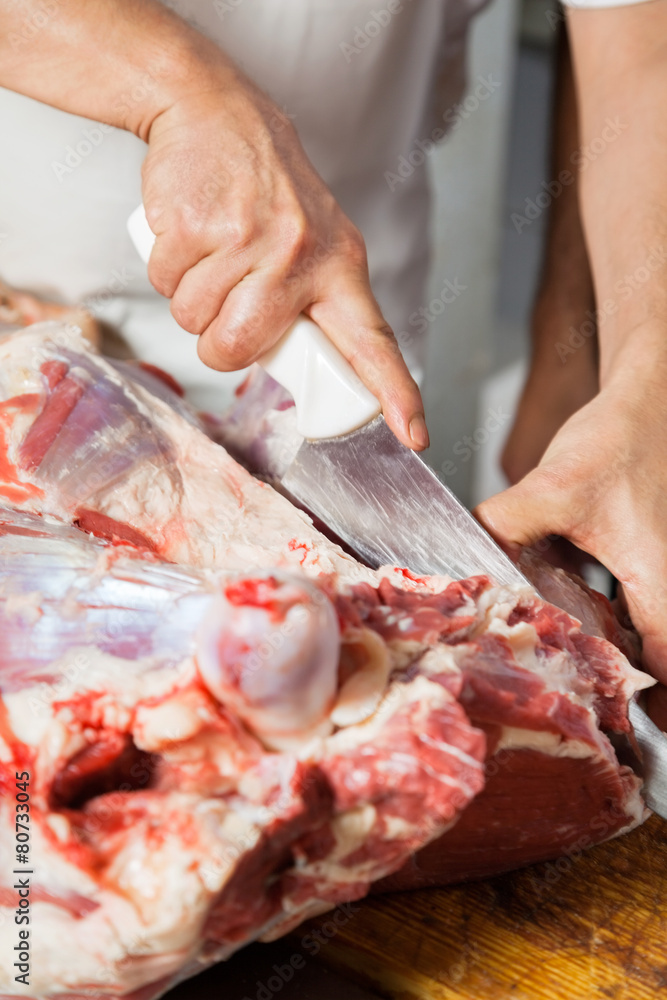 Cropped Image Of Butcher Cutting Meat