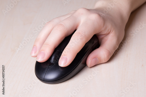 mouse in female hand on wooden table