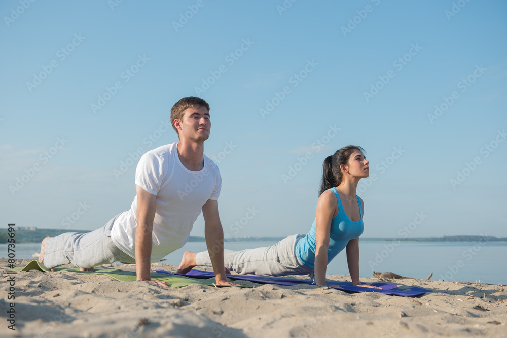 Fototapeta premium Young couple doing yoga
