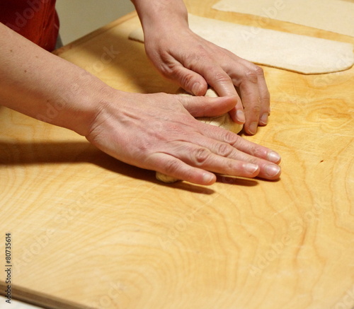Detail of the hands of an Italian woman making home made pasta