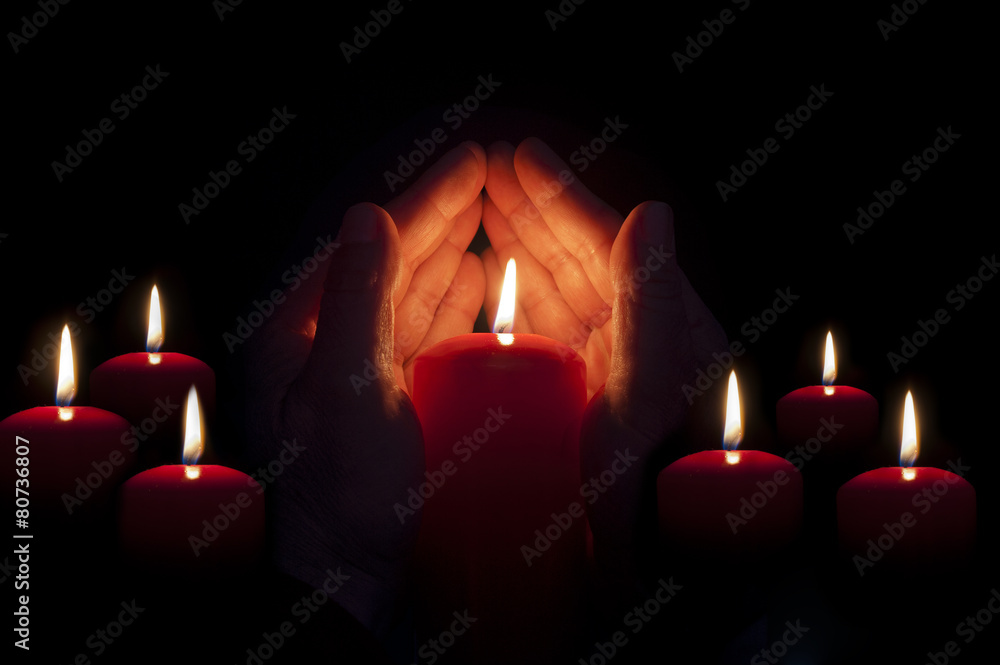 two hands illuminated by a candle in the darkness two hands illuminated by a candle in the darkness