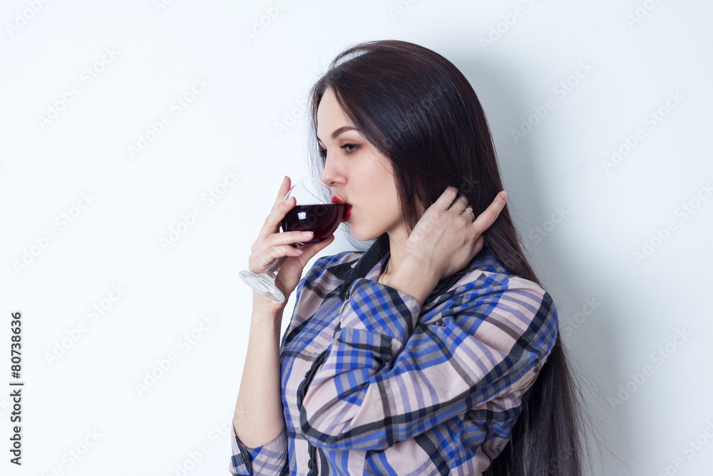 Young woman stroking her hair and drinking red wine Young woman stroking her hair and drinking red wine