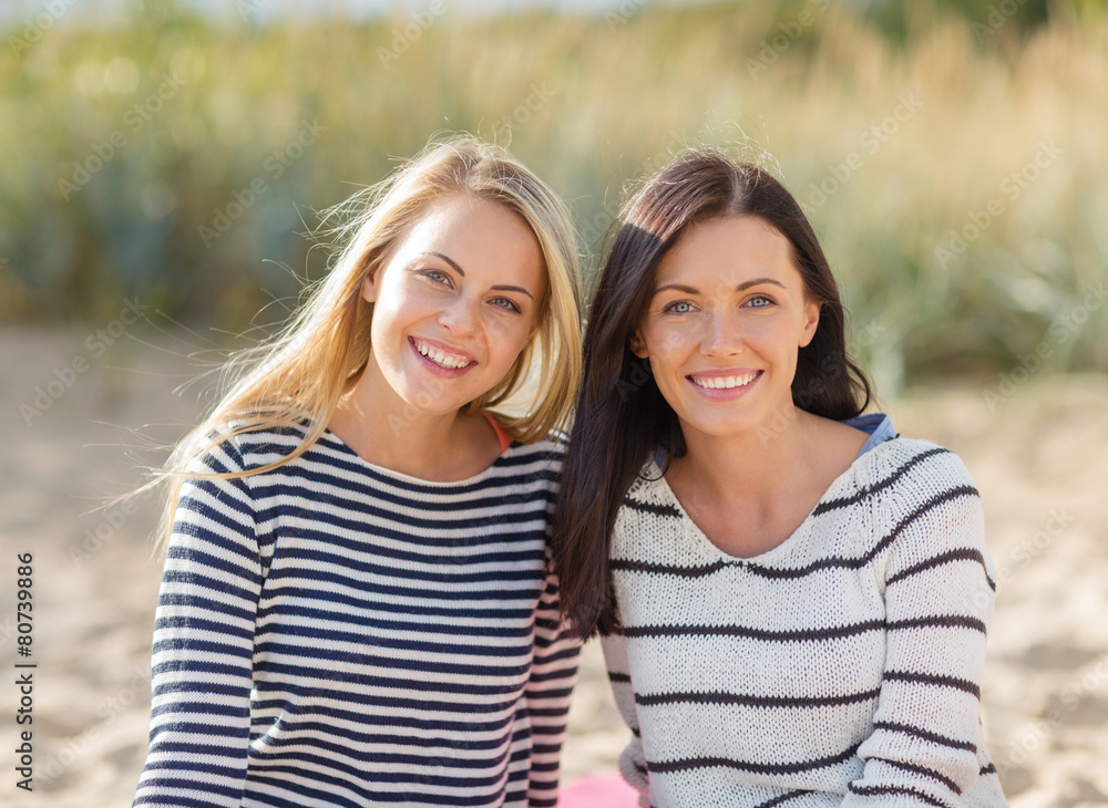Obraz premium happy teenage girls or young women on beach