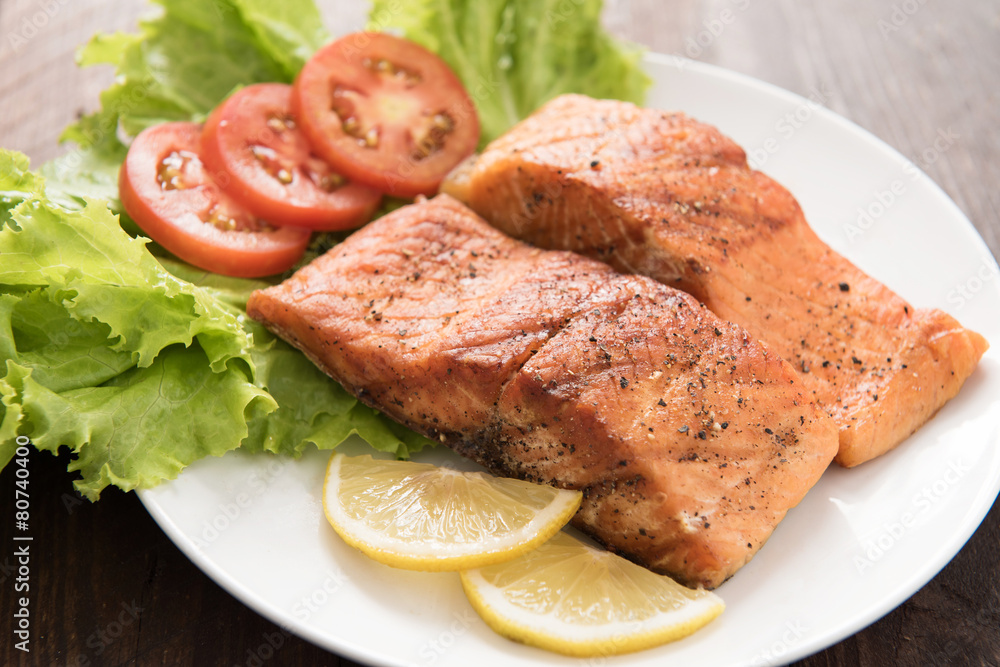 Grilled salmon fillet cooked BBQ and served with fresh herbs and Grilled salmon fillet cooked BBQ and served with fresh herbs and