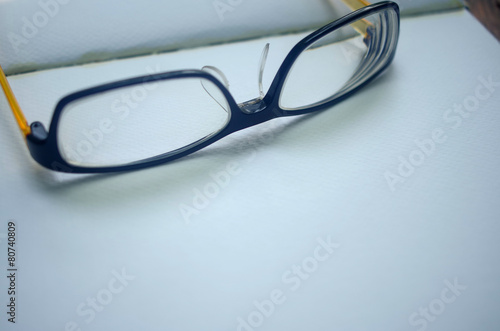 closeup open empty notebook with glasses on wooden table