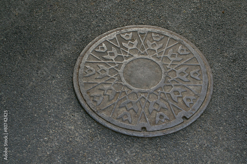 Metal circle of drain water on pavement