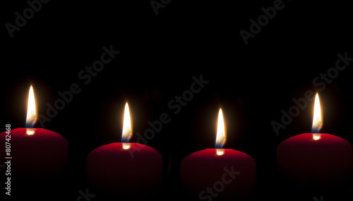 red candles lighting in the darkness