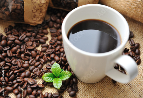 Cup of coffee with beans and leaf