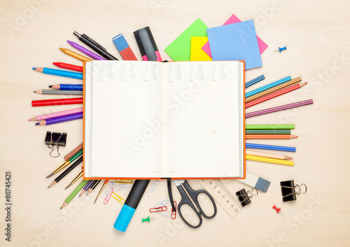 Blank notepad over school and office supplies