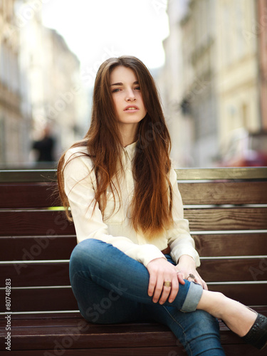 Fashion portrait stylish urban girl posing in old city street © okostia