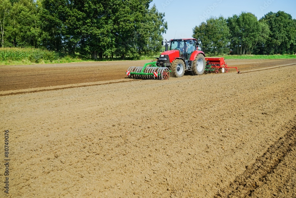 Obraz premium Roter Schlepper mit schwerer Drillmaschine