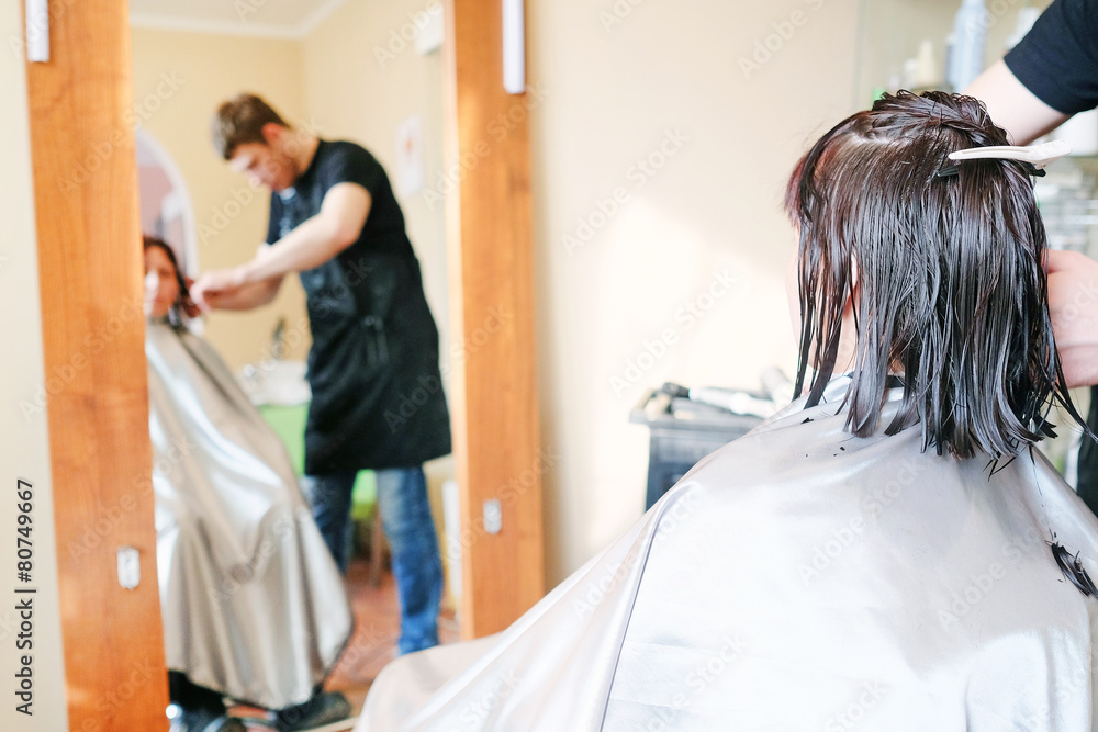 Hairdresser making a haircut for a brunette women Hairdresser making a haircut for a brunette women