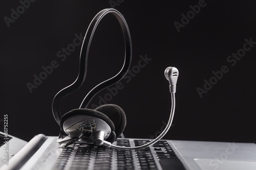 Leinwand Poster Angle. Headset lying on a laptop computer keyboard conceptual of