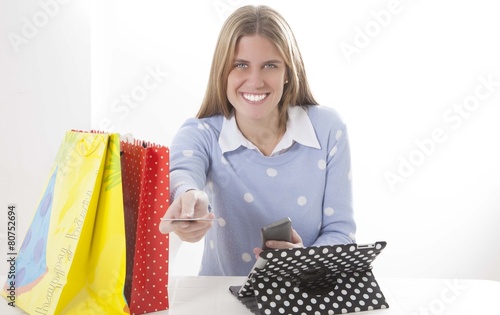 Blond girl with shopping bags and laptop