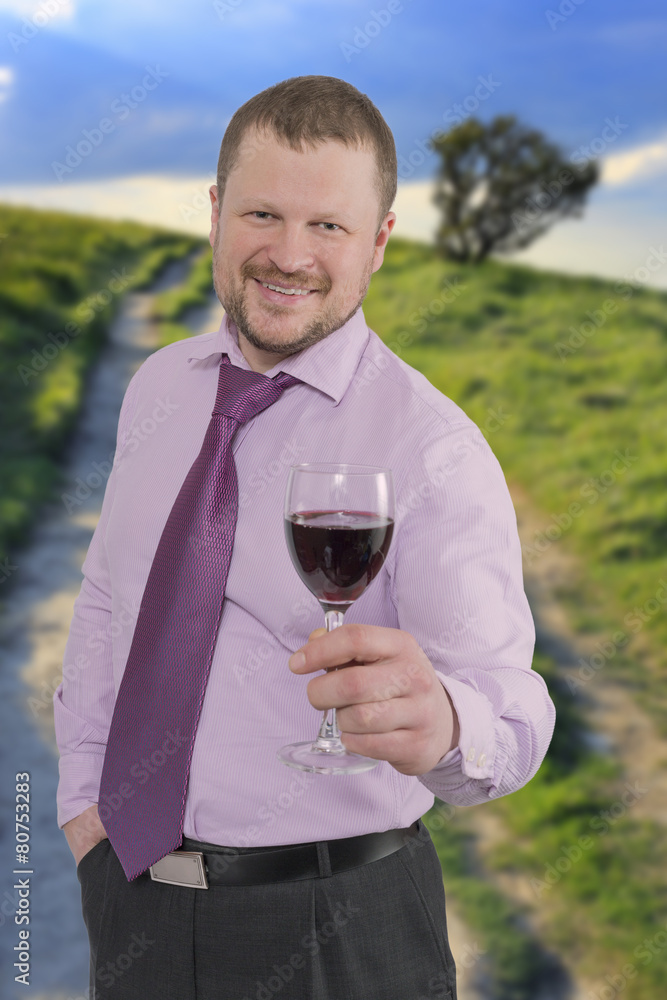 Businessman holding glass of wine with sunset landscape in Businessman holding glass of wine with sunset landscape in
