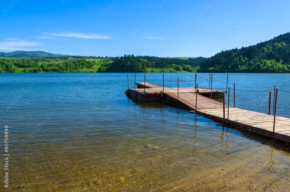 Wooden jetty on Czorsztynskie lake in spring landscape of Poland