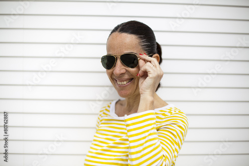 Mujer con jersey de rayas amarillo y gafas de sol photo