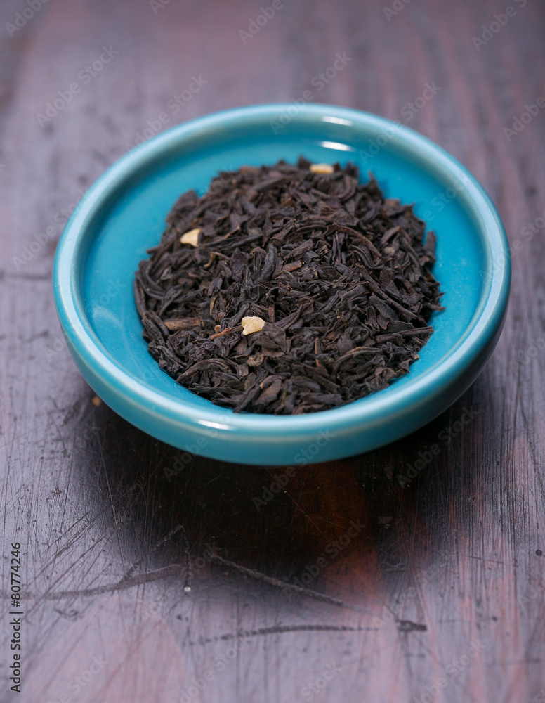 Bowl of dried green tea leaves on wooden background Bowl of dried green tea leaves on wooden background
