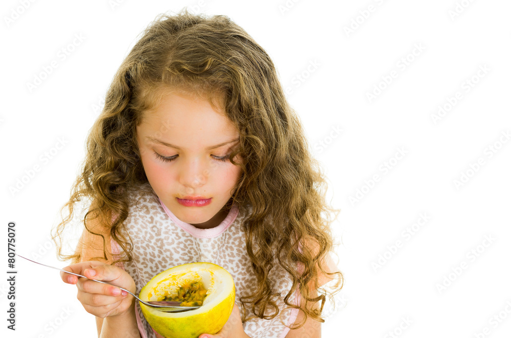 Cute little preschooler girl holding a passion fruit half Cute little preschooler girl holding a passion fruit half