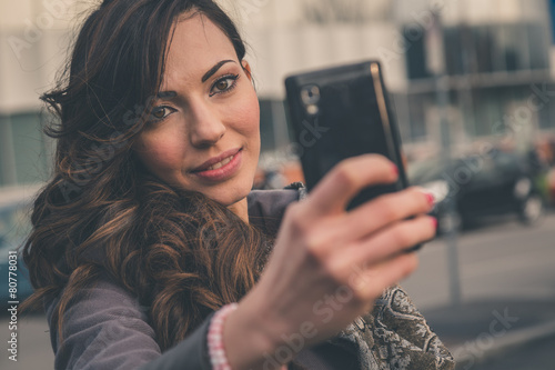 Beautiful girl taking a selfie in an urban context