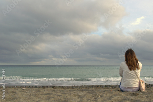 Seduti sulla spiaggia al mare photo