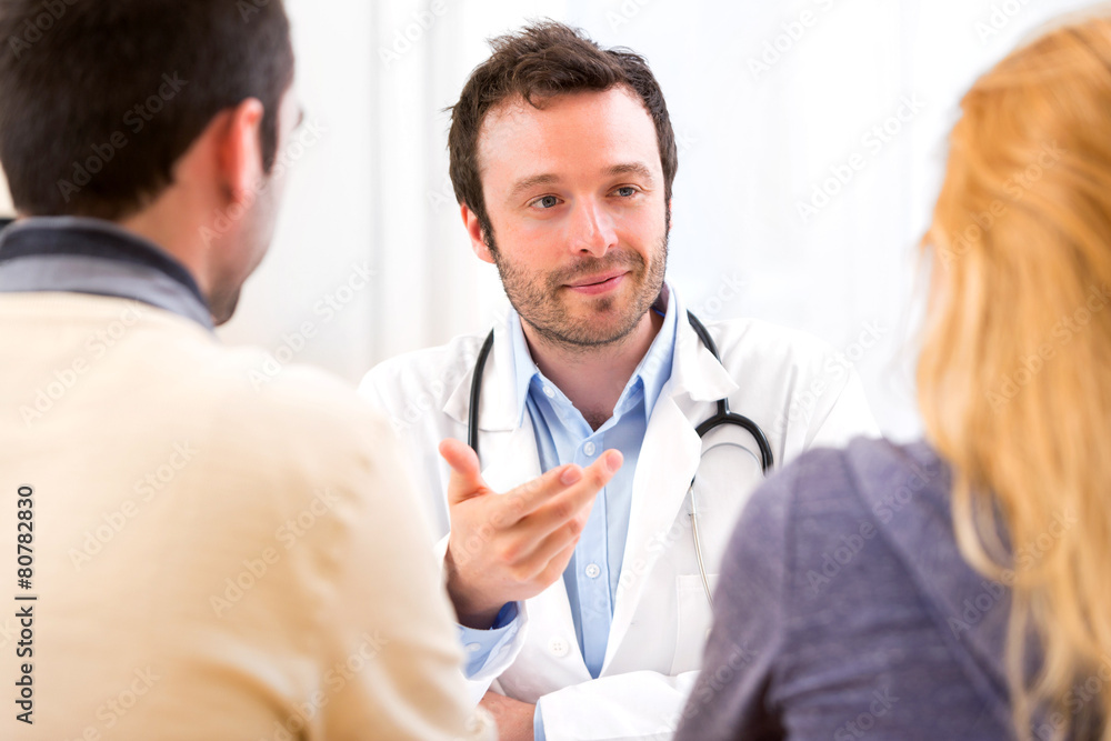 Young attractive doctor advising a young couple of patients Young attractive doctor advising a young couple of patients