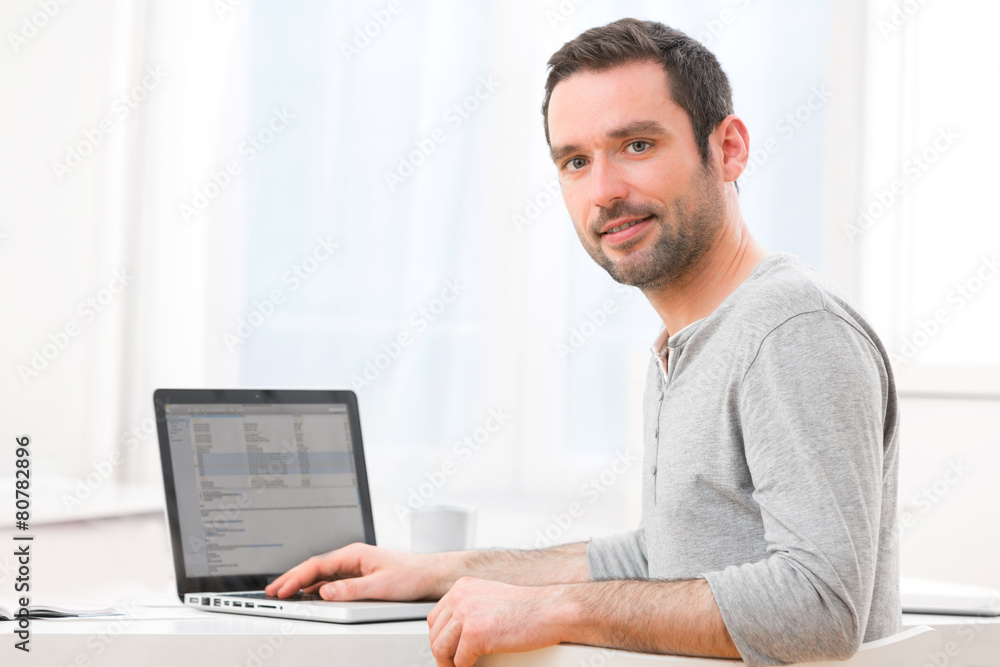 Young smiling man in front of a computer Young smiling man in front of a computer