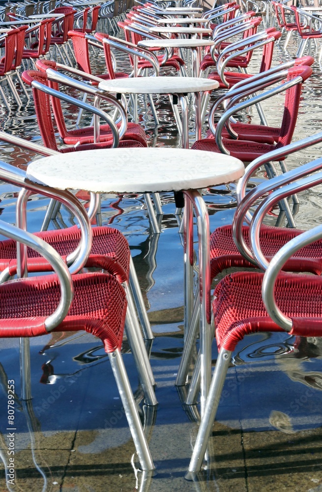 Venice, chairs of the outdoor cafes with water at high tide Venice, chairs of the outdoor cafes with water at high tide
