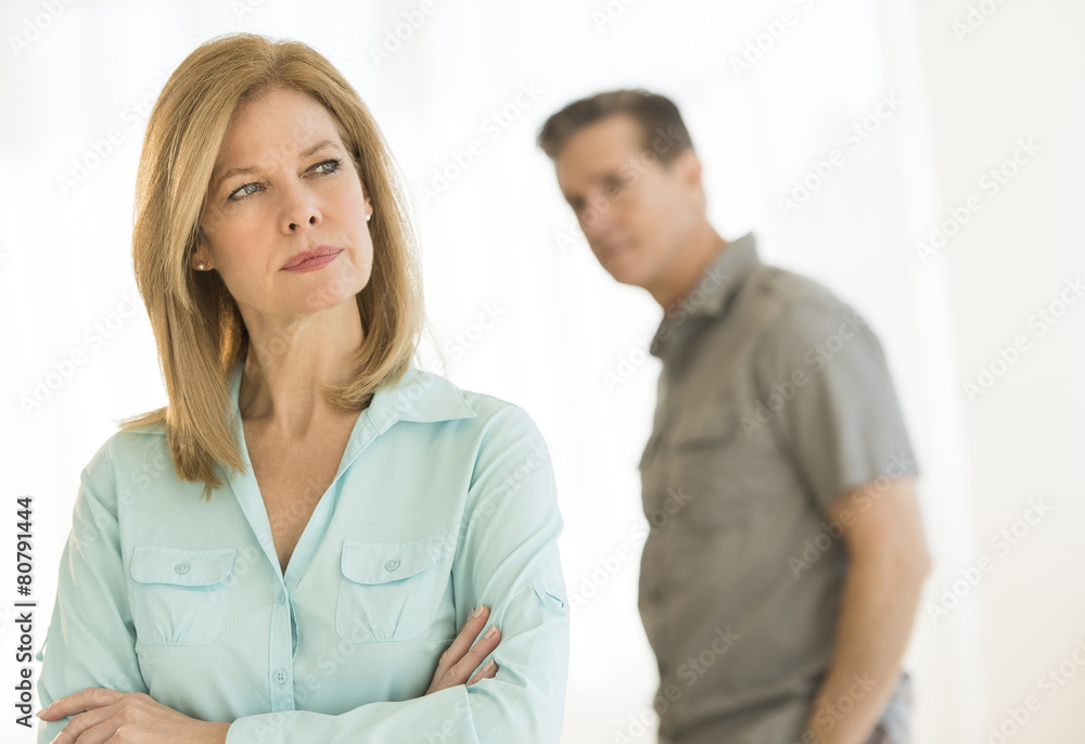 Angry Woman Looking Away With Man In Background At Home Angry Woman Looking Away With Man In Background At Home