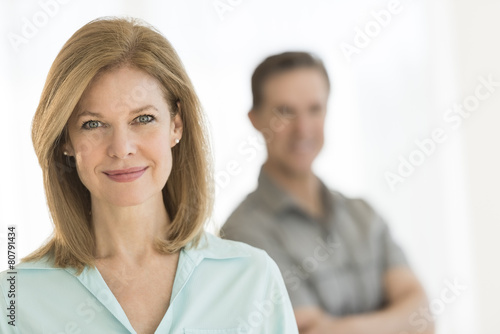 Mature Woman Smiling With Man Standing In Background