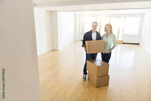 Happy Mature Couple With Cardboard Boxes In New House