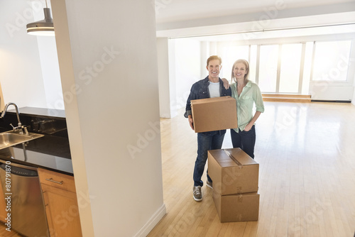 Happy Mature Couple With Cardboard Boxes At New Home