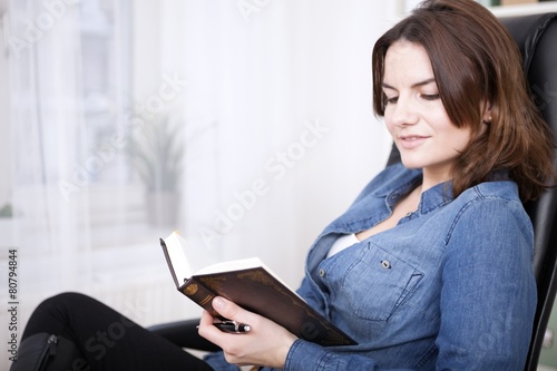 Smiling Office Woman on a Chair Reading a Book