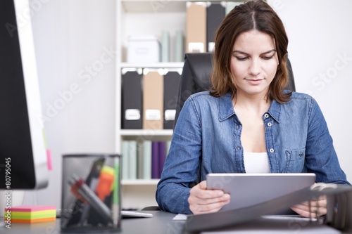 Businesswoman reading information on her tablet
