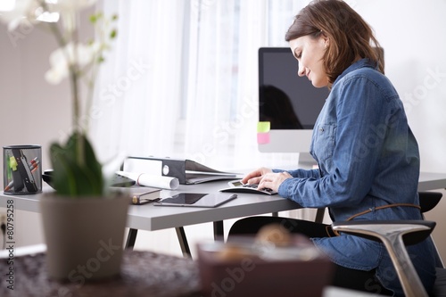 Busy Young Businesswoman Sitting at her Worktable