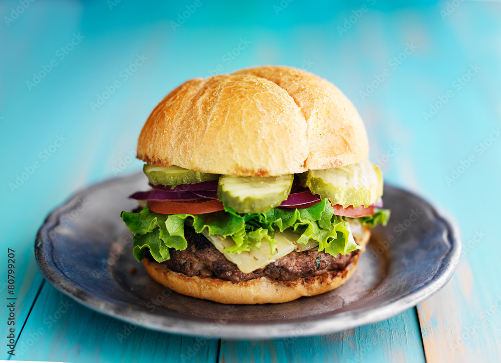 hamburger with pickles on retro rustic painted wood planks hamburger with pickles on retro rustic painted wood planks
