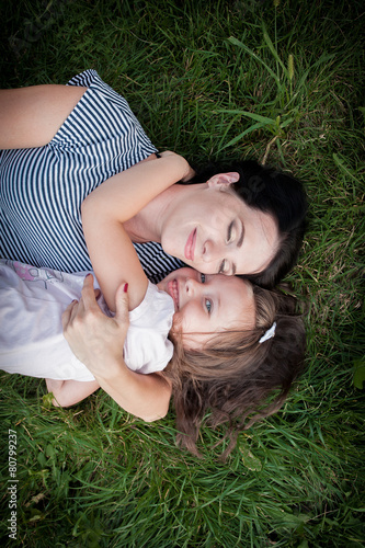 mother and daughter on the grass top view