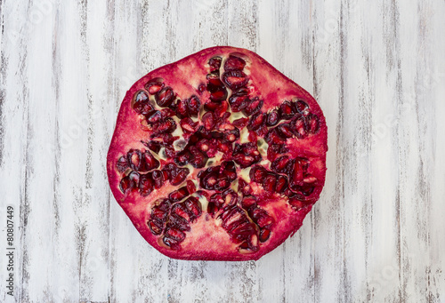 Pomegranate section overhead view on a white wooden kitchen table photo