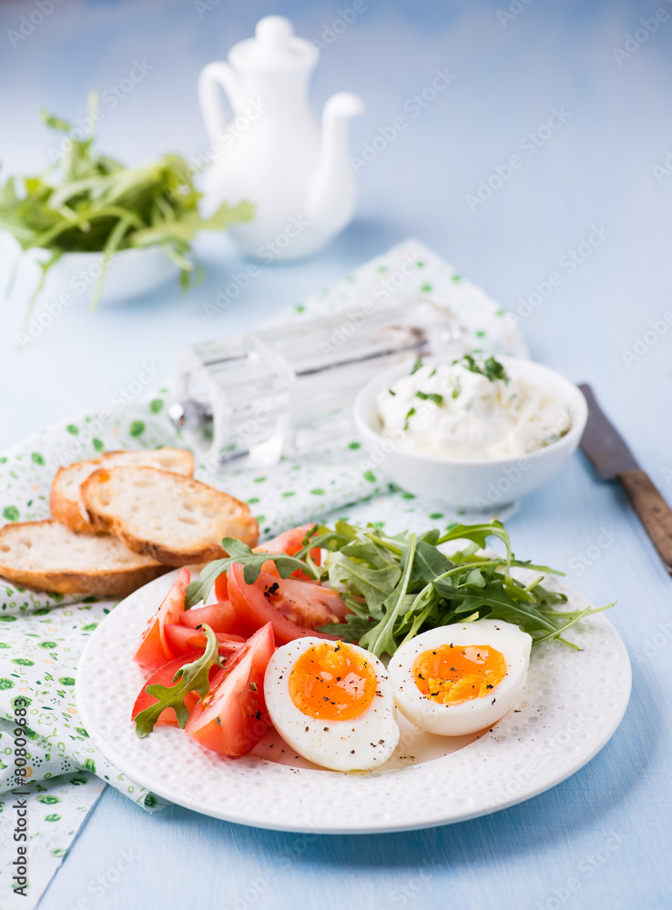 Breakfast with soft-boiled egg, arugula and tomatoes Breakfast with soft-boiled egg, arugula and tomatoes