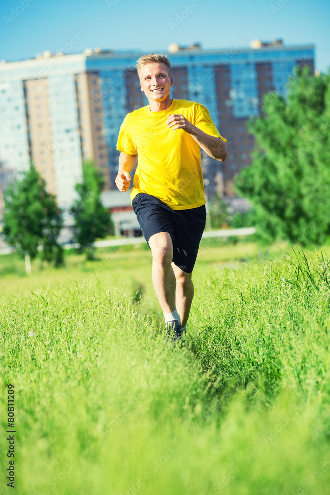 Sporty man jogging in city street park. Outdoor fitness. Sporty man jogging in city street park. Outdoor fitness.