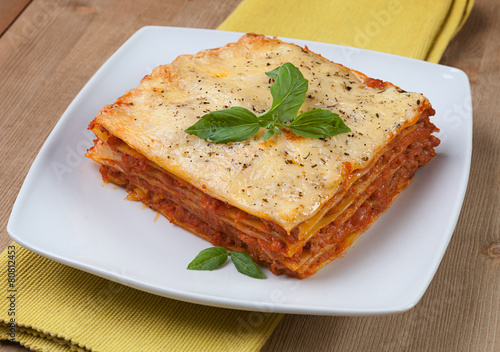 Tasty flavorful lasagna on a plate and ingredients