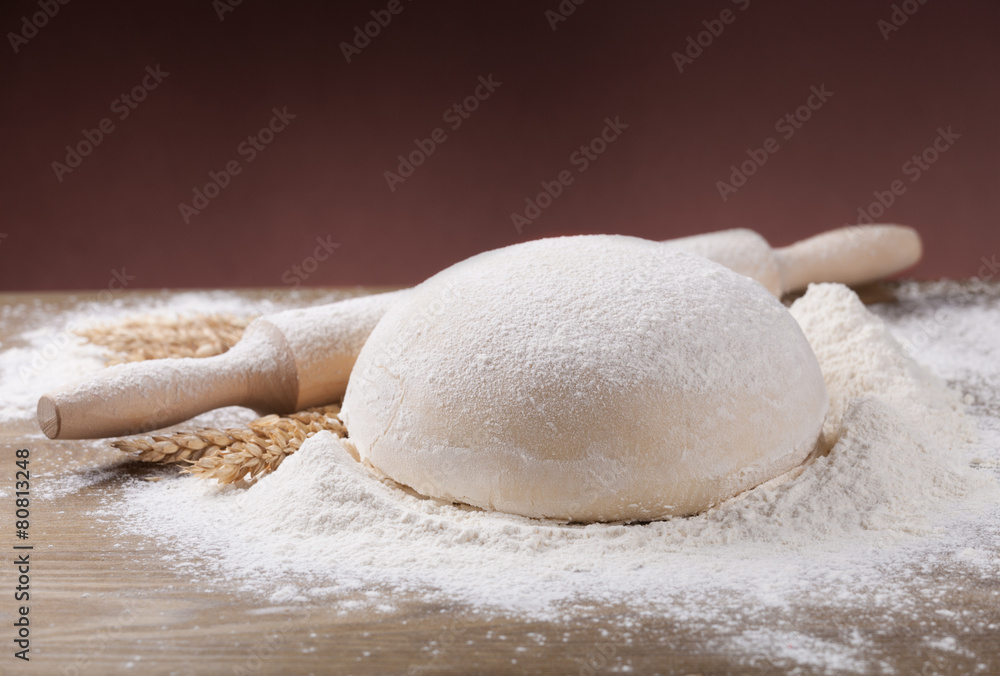 Flour, dough and rolling pin spikes on the board Flour, dough and rolling pin spikes on the board