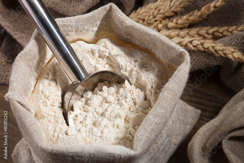 Scoop and flour in a bag on the old board