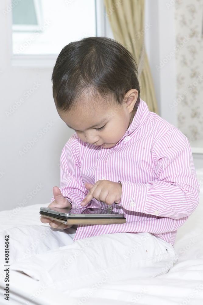 Cute Little boy using mobile phone at home Cute Little boy using mobile phone at home