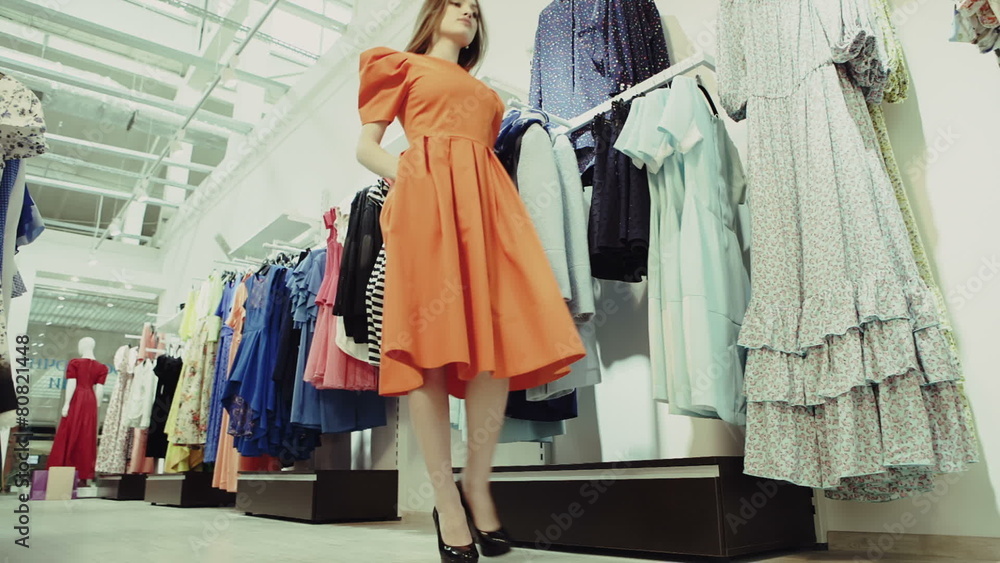 Beautiful girl trying dress near mirror in room Beautiful girl trying dress near mirror in room