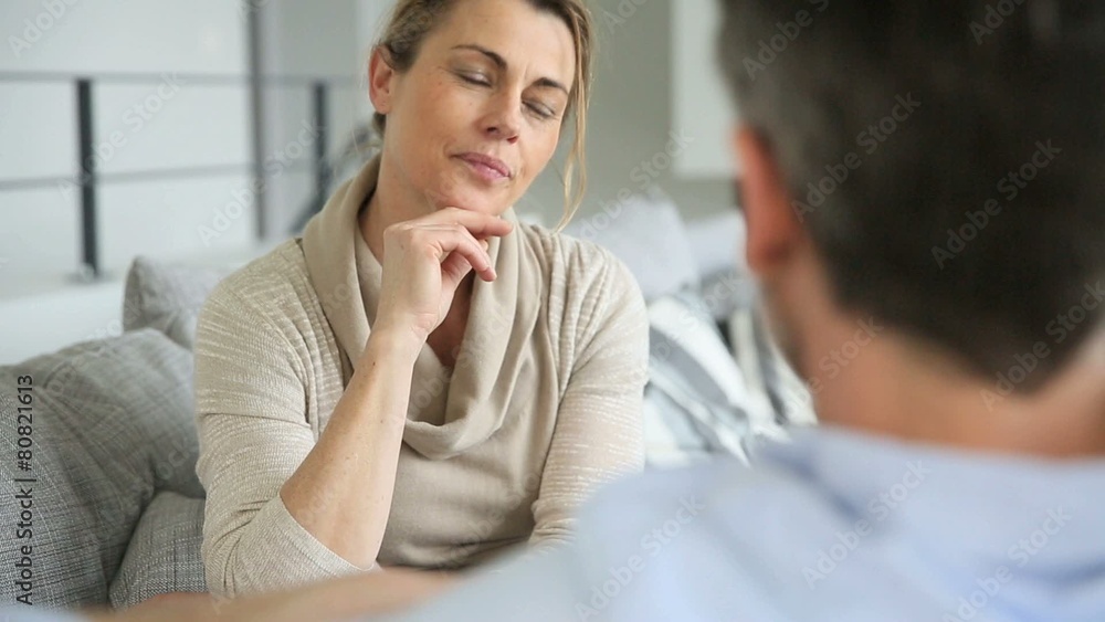 Couple at home sitting in sofa and having a talk Couple at home sitting in sofa and having a talk