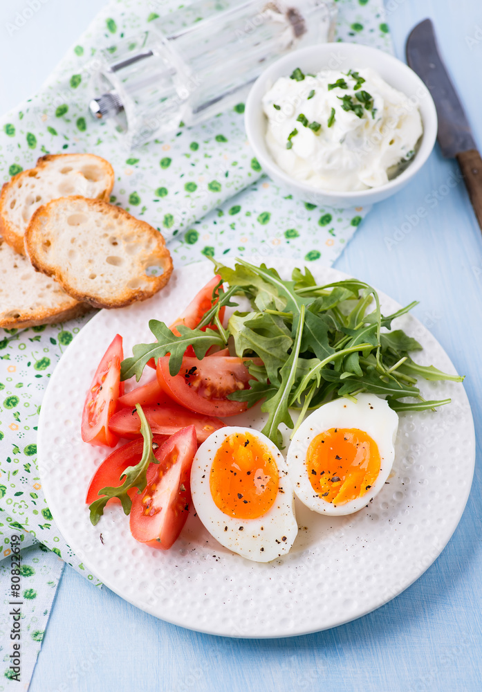 Breakfast with soft-boiled egg, arugula and tomatoes Breakfast with soft-boiled egg, arugula and tomatoes